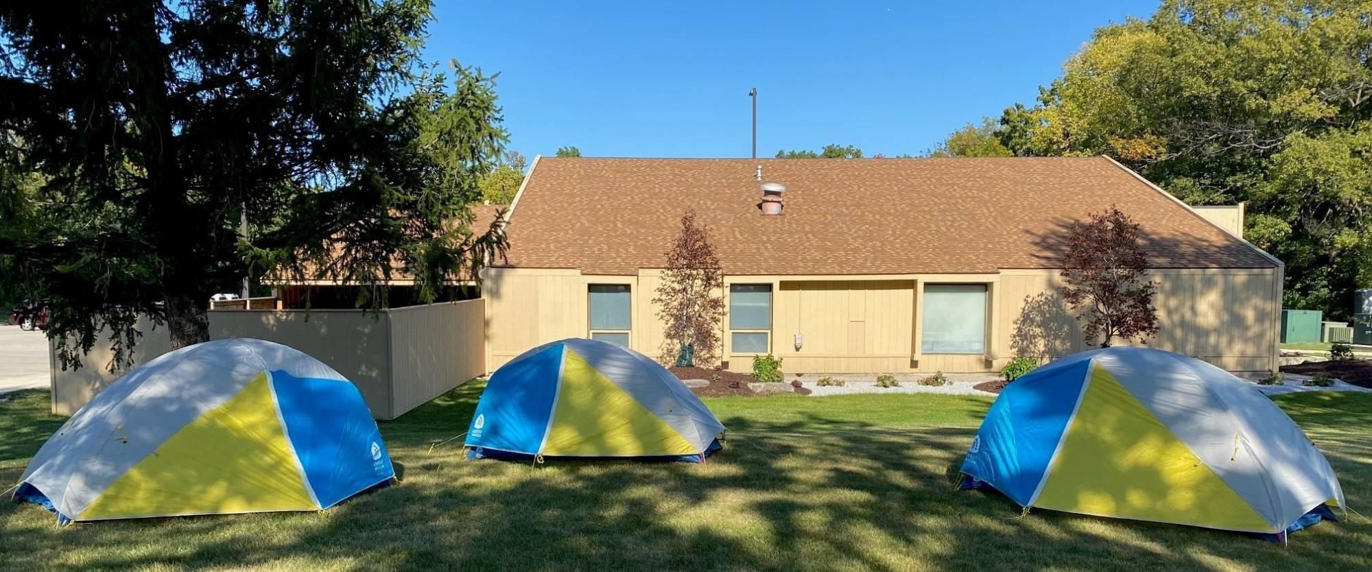 OA headquarters on a sunny day with 3 tents in the lawn